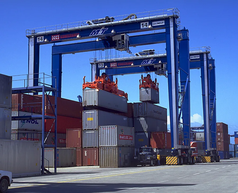 Blue quay gantry cranes lifting containers at port